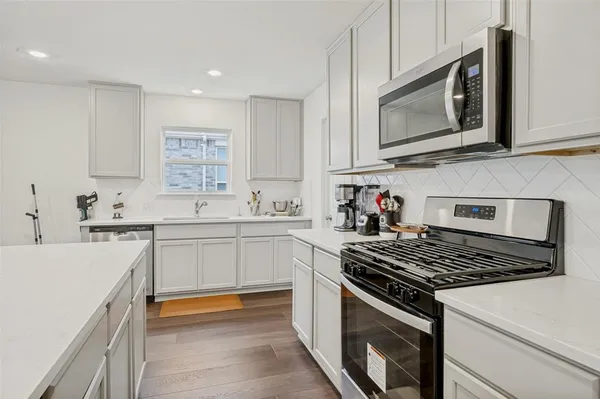 a kitchen with granite countertop white cabinets and white appliances
