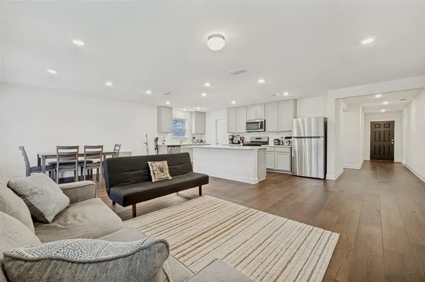 a living room with furniture a dining table and a wooden floor