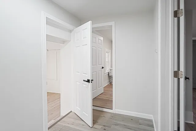 an empty room with wooden floor & windows