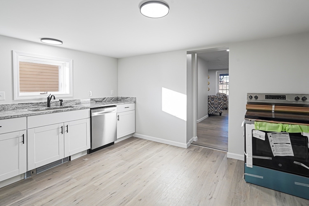 757 Main Street, Unit A Southbridge, MA 01550 - Photo 3 of 32 a kitchen with a sink wooden floor and a stove