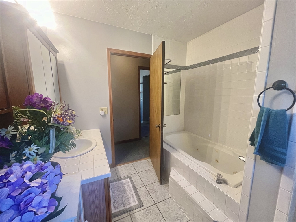 31 Putnam Road Sturbridge, MA 01566 - Photo 12 of 34 a bathroom with a tub shower sink and mirror
