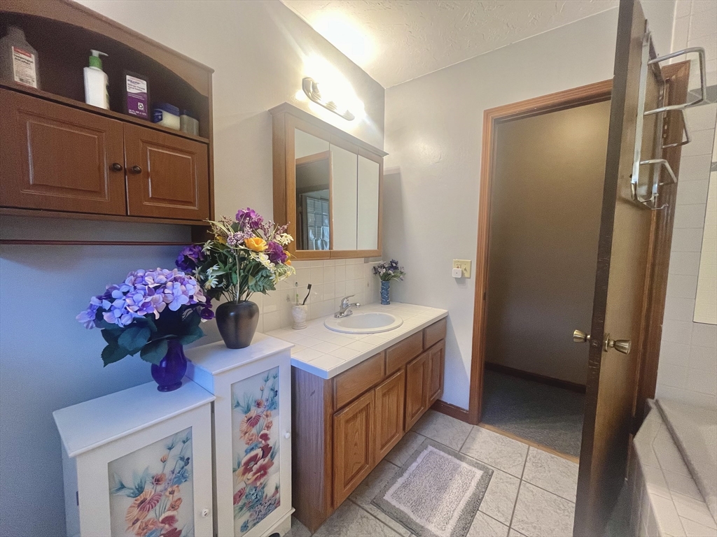 31 Putnam Road Sturbridge, MA 01566 - Photo 14 of 34 a bathroom with a sink mirror and cabinets