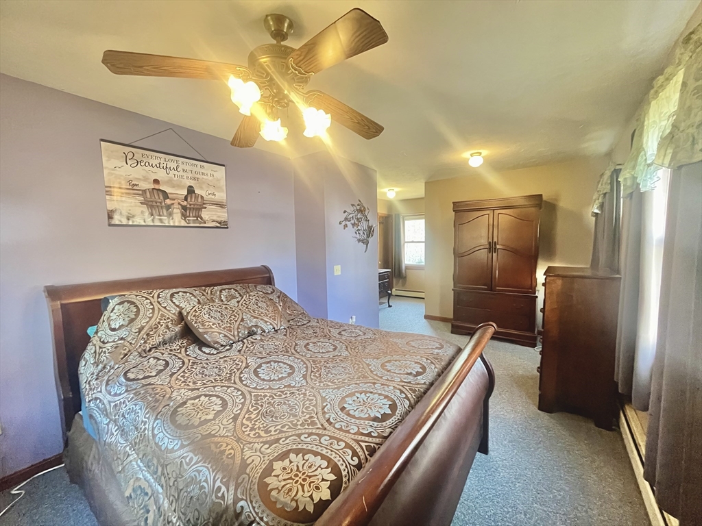 31 Putnam Road Sturbridge, MA 01566 - Photo 19 of 34 a spacious bedroom with a bed and a chandelier