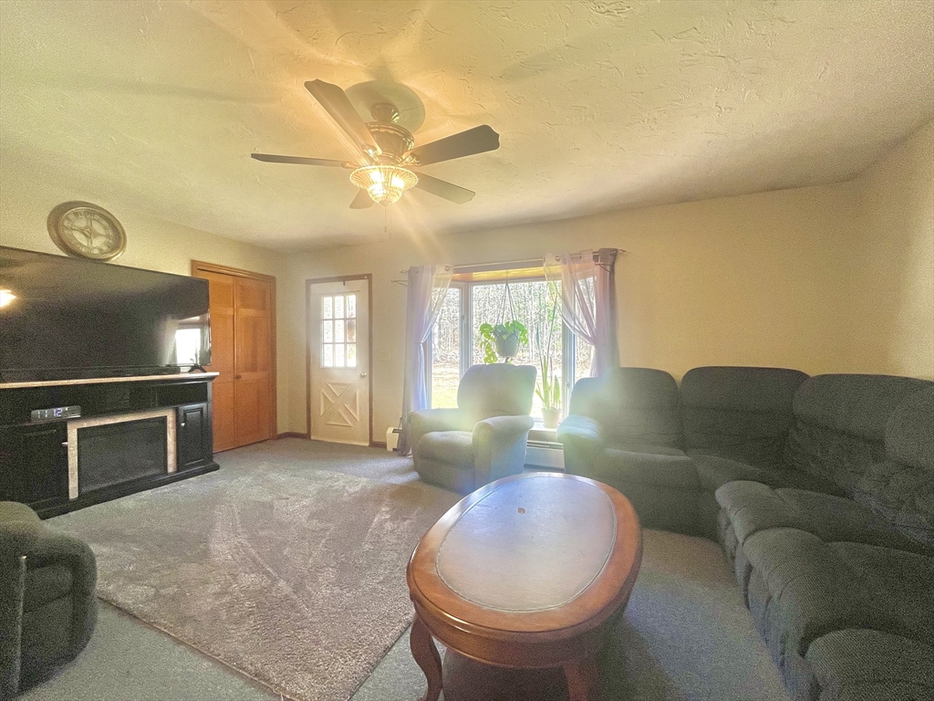 31 Putnam Road Sturbridge, MA 01566 - Photo 8 of 34 a living room with furniture a flat screen tv and a fireplace