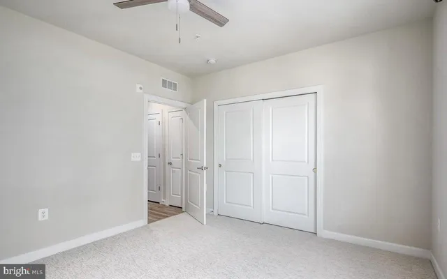 an empty room with a ceiling fan and entryway