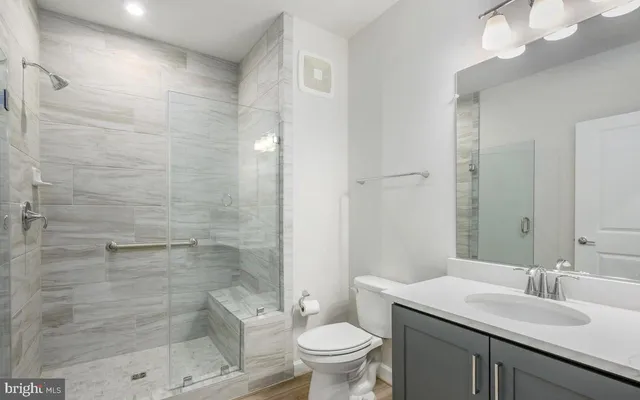 a bathroom with a sink a toilet and shower