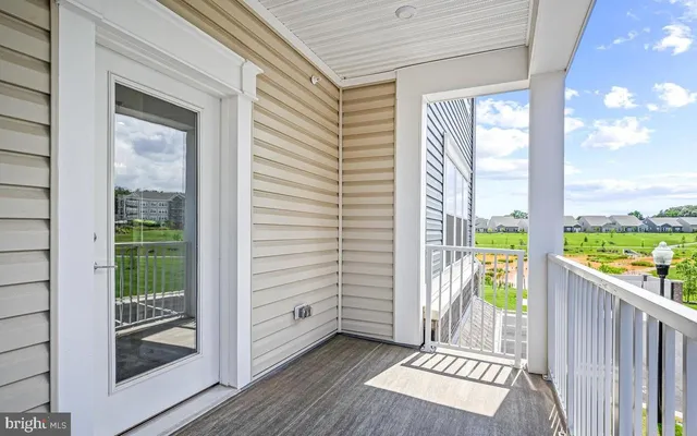 a view of a balcony with floor to ceiling window wooden floor and fence