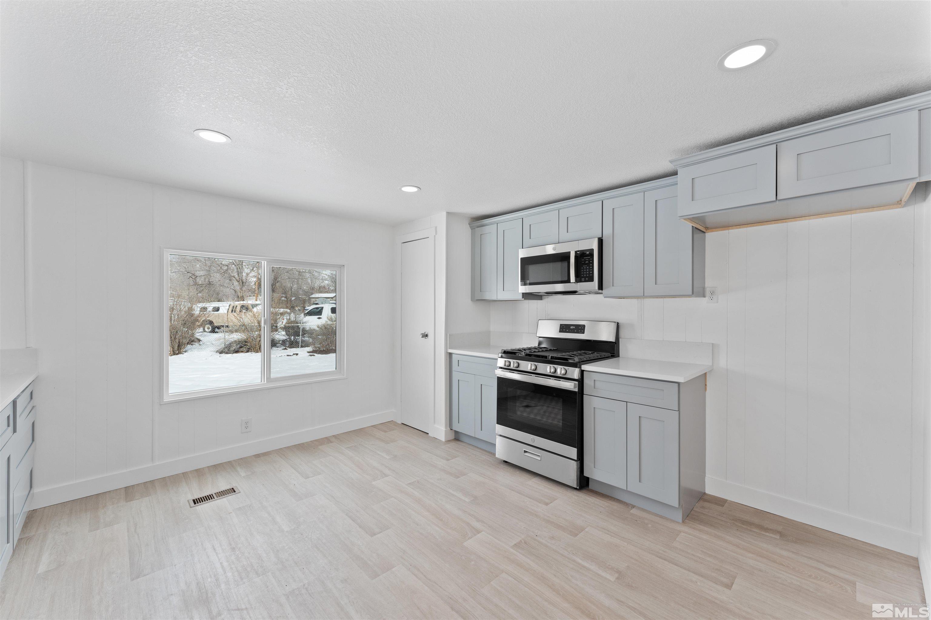 3993 Kiwi Court Reno, NV 89508 - Photo 5 of 39 a kitchen with stainless steel appliances granite countertop a stove a sink and a refrigerator