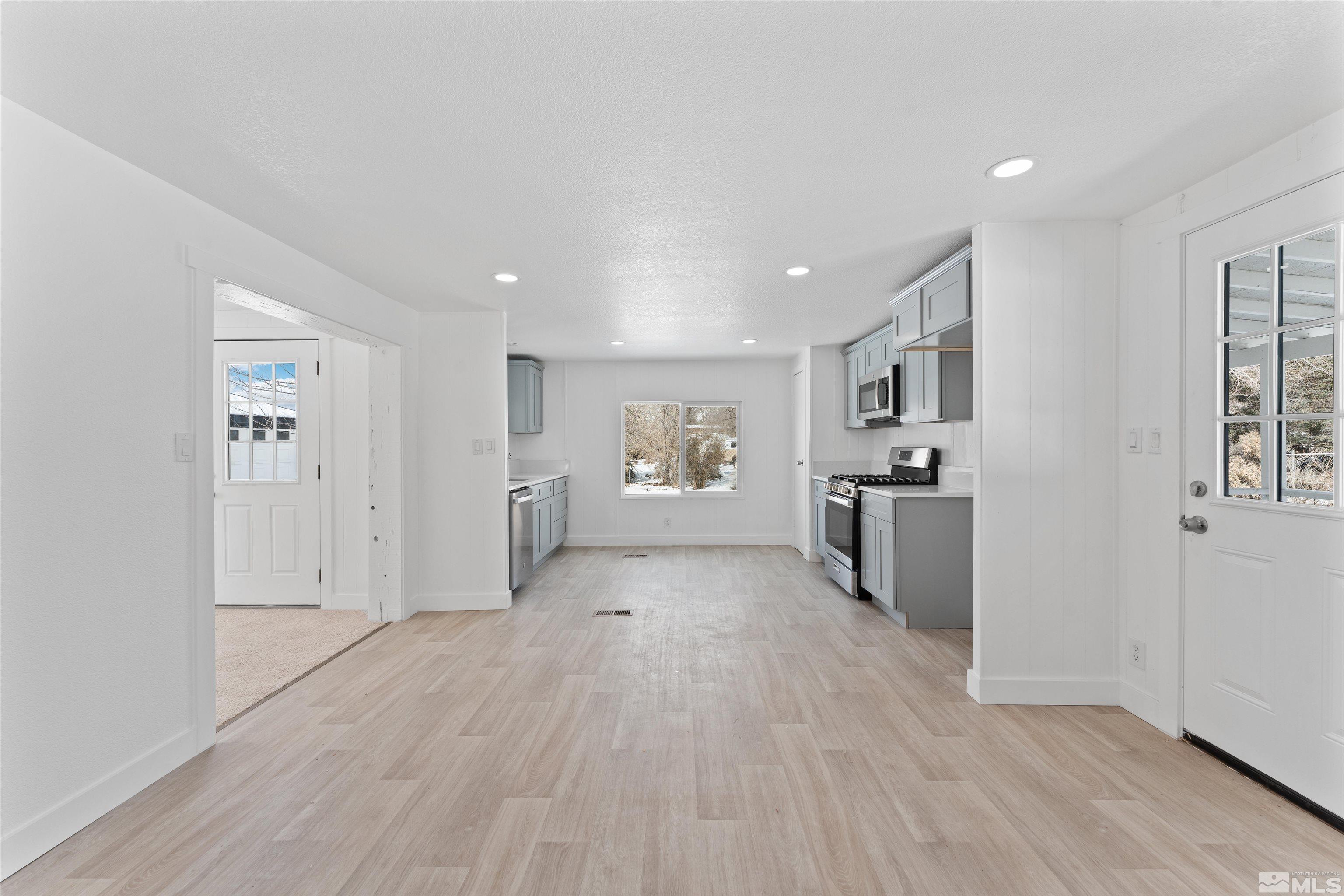 3993 Kiwi Court Reno, NV 89508 - Photo 9 of 39 a view of a large room with wooden floor and windows