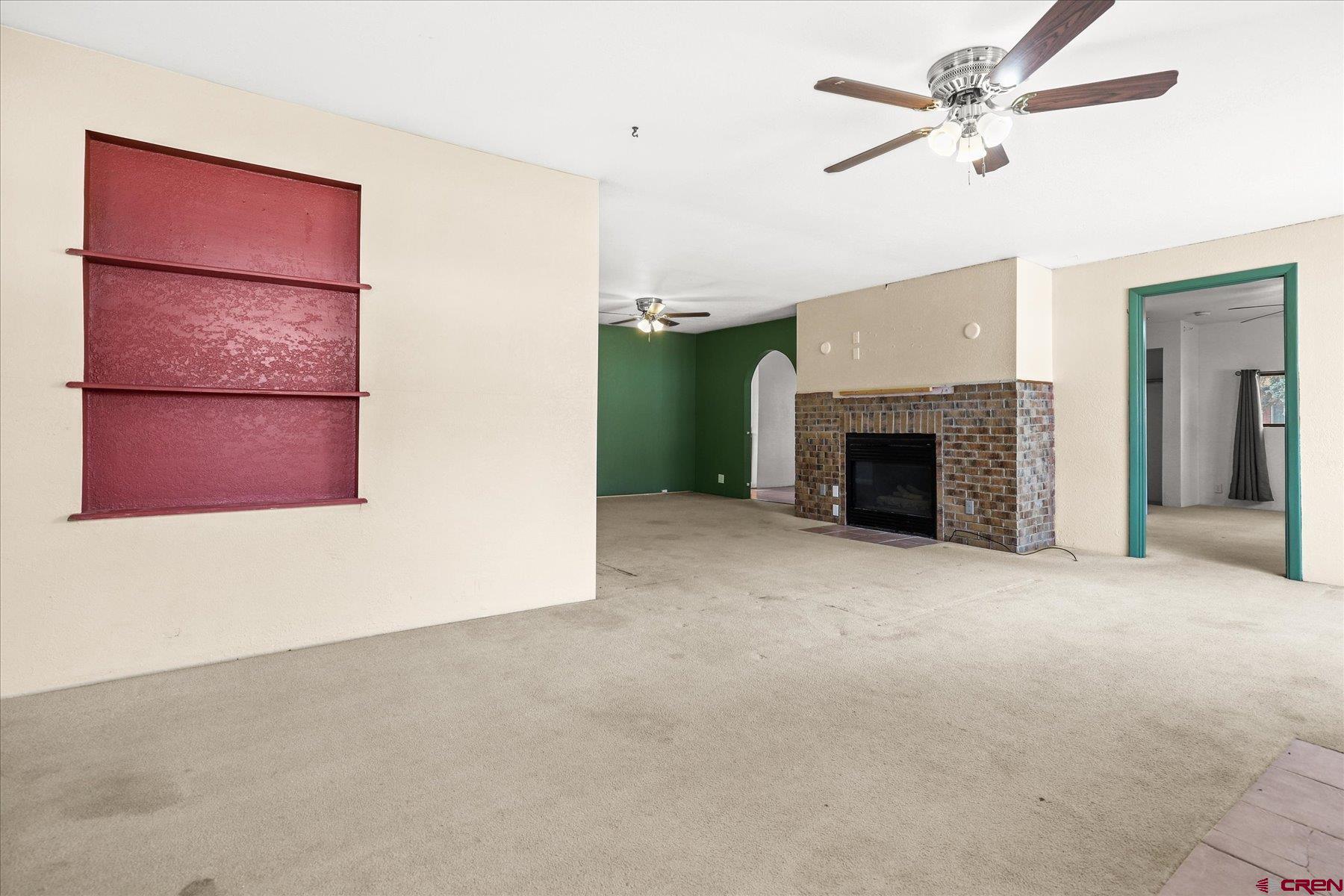 403 East 3rd Street Cortez, CO 81321 - Photo 4 of 31 an empty room with a fireplace and fan