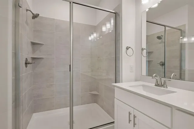 a bathroom with a shower sink and mirror