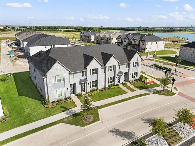 an aerial view of residential houses with outdoor space and ocean view