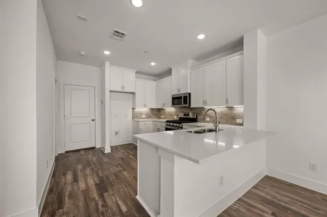 a kitchen with cabinets a sink and appliances