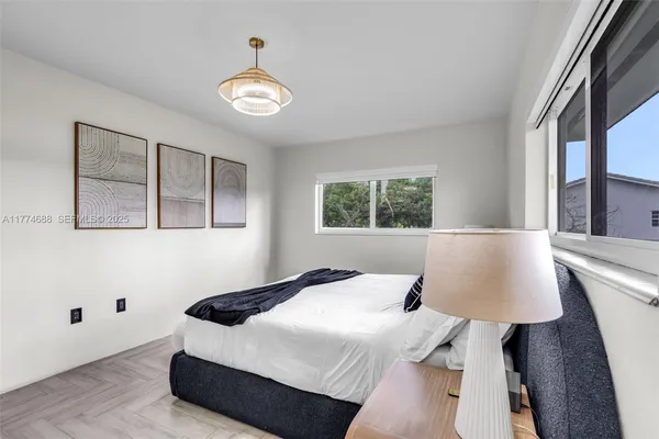 a bedroom with two bed and a potted plant