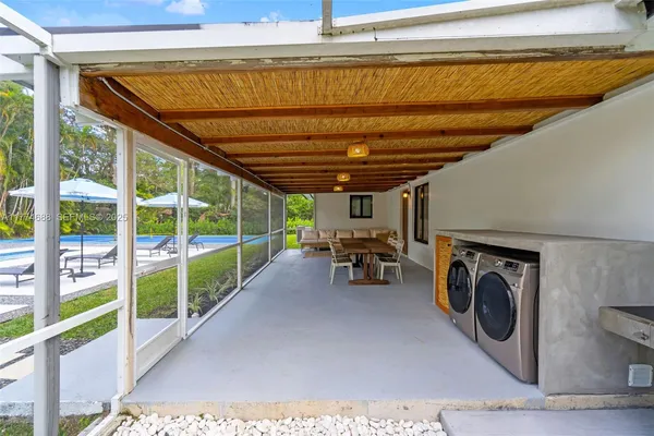 a front view of a house with swimming pool having outdoor seating