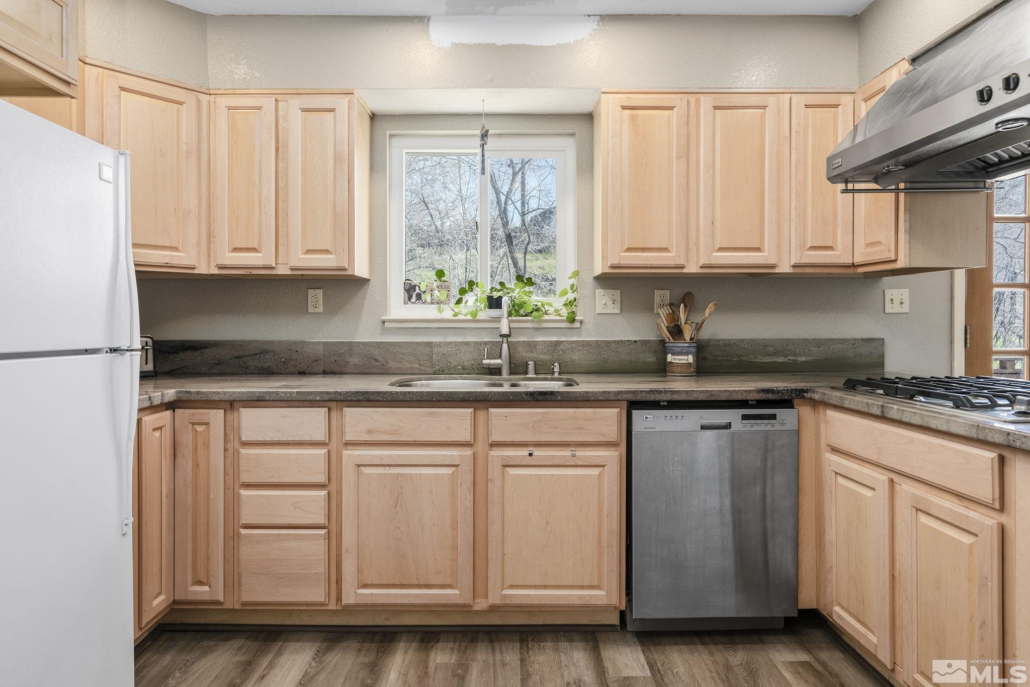 2000 Keystone Avenue Reno, NV 89503 - Photo 7 of 19 a kitchen with stainless steel appliances granite countertop a sink a stove and a refrigerator