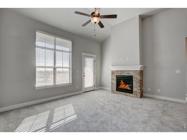 a living room with furniture a fireplace and a large window