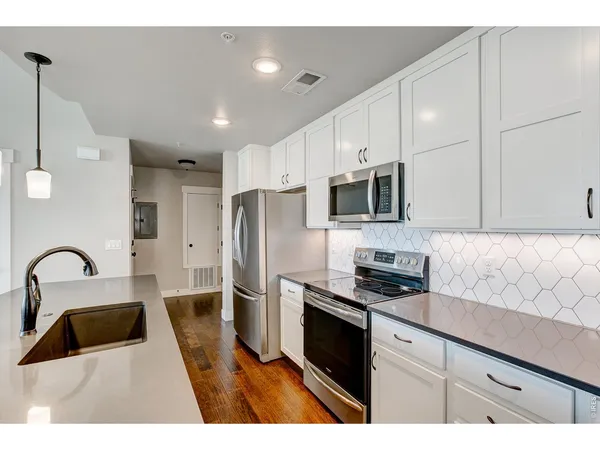a kitchen with granite countertop a refrigerator and a sink