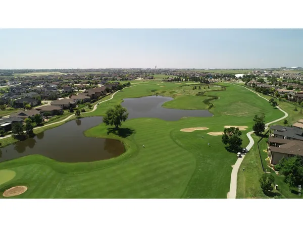 an aerial view of a houses with a yard and lake view