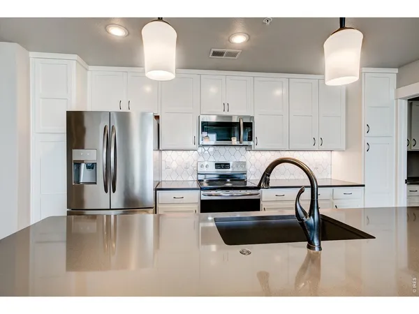a kitchen with stainless steel appliances a refrigerator sink a stove a microwave and cabinets