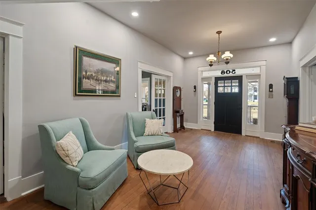 a living room with furniture a dining table and a chandelier