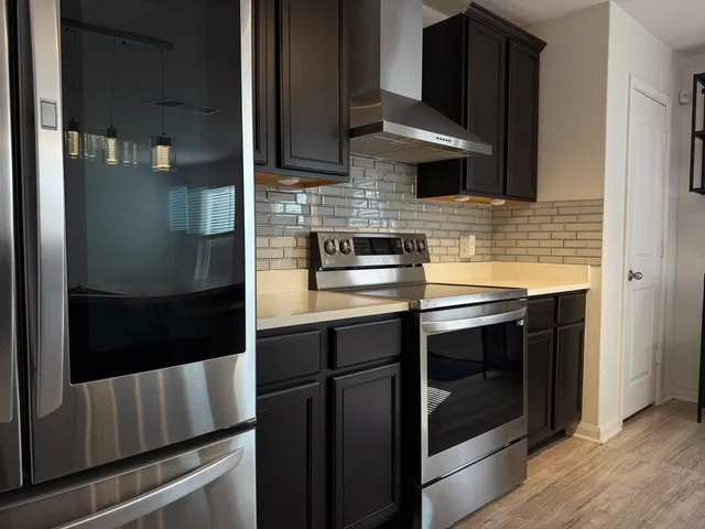 a kitchen with stainless steel appliances granite countertop a stove and a refrigerator