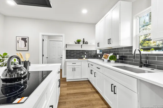 a kitchen with stainless steel appliances a sink stove and cabinets