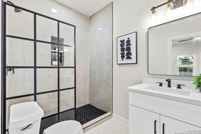 a bathroom with a sink mirror vanity and toilet