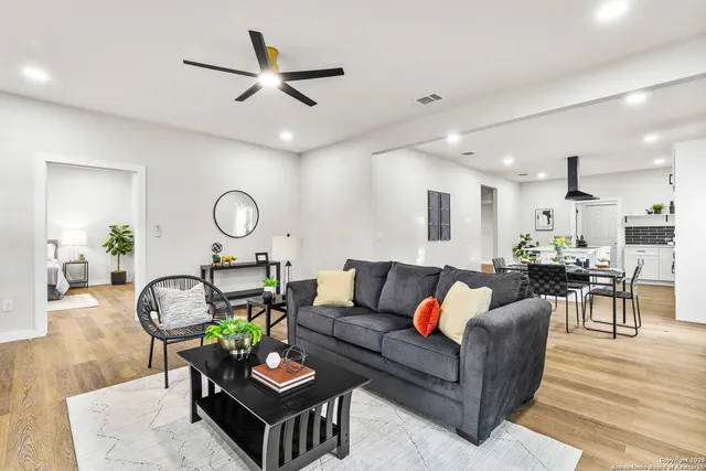 a living room with furniture kitchen and a chandelier