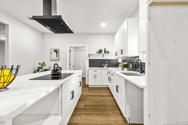 a large white kitchen with stainless steel appliances