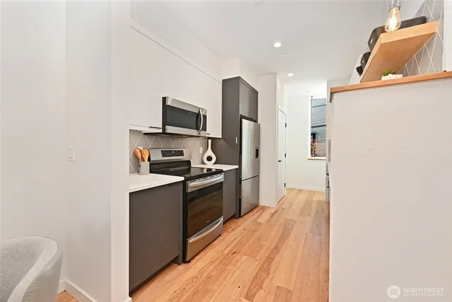 a kitchen with stainless steel appliances granite countertop a refrigerator and a stove top oven