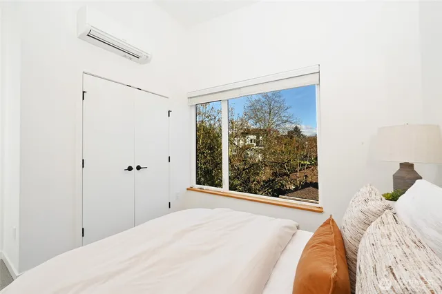 a bed sitting in a bedroom next to a window