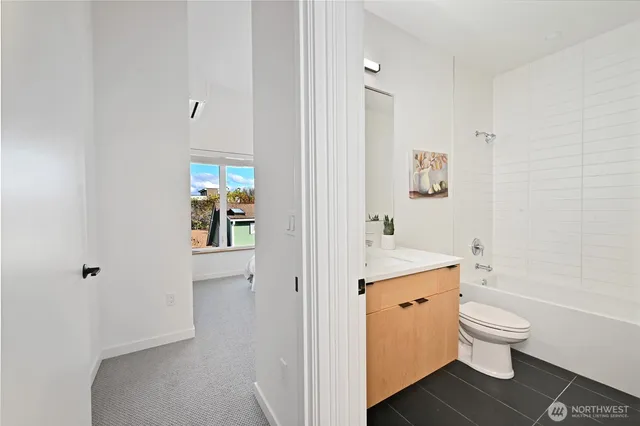 a bathroom with a granite countertop toilet a sink and a mirror