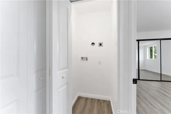 a view of a hallway with wooden floor and closet