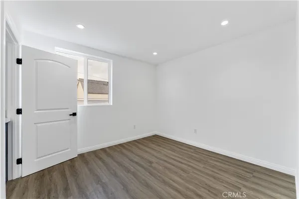 a view of a room with wooden floor and white walls