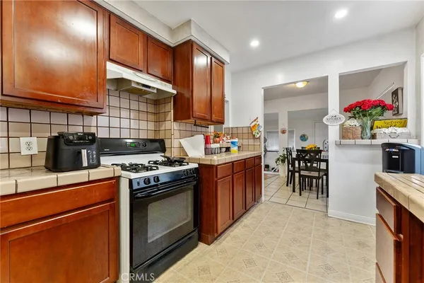 a kitchen with stainless steel appliances granite countertop a stove a sink dishwasher and a refrigerator