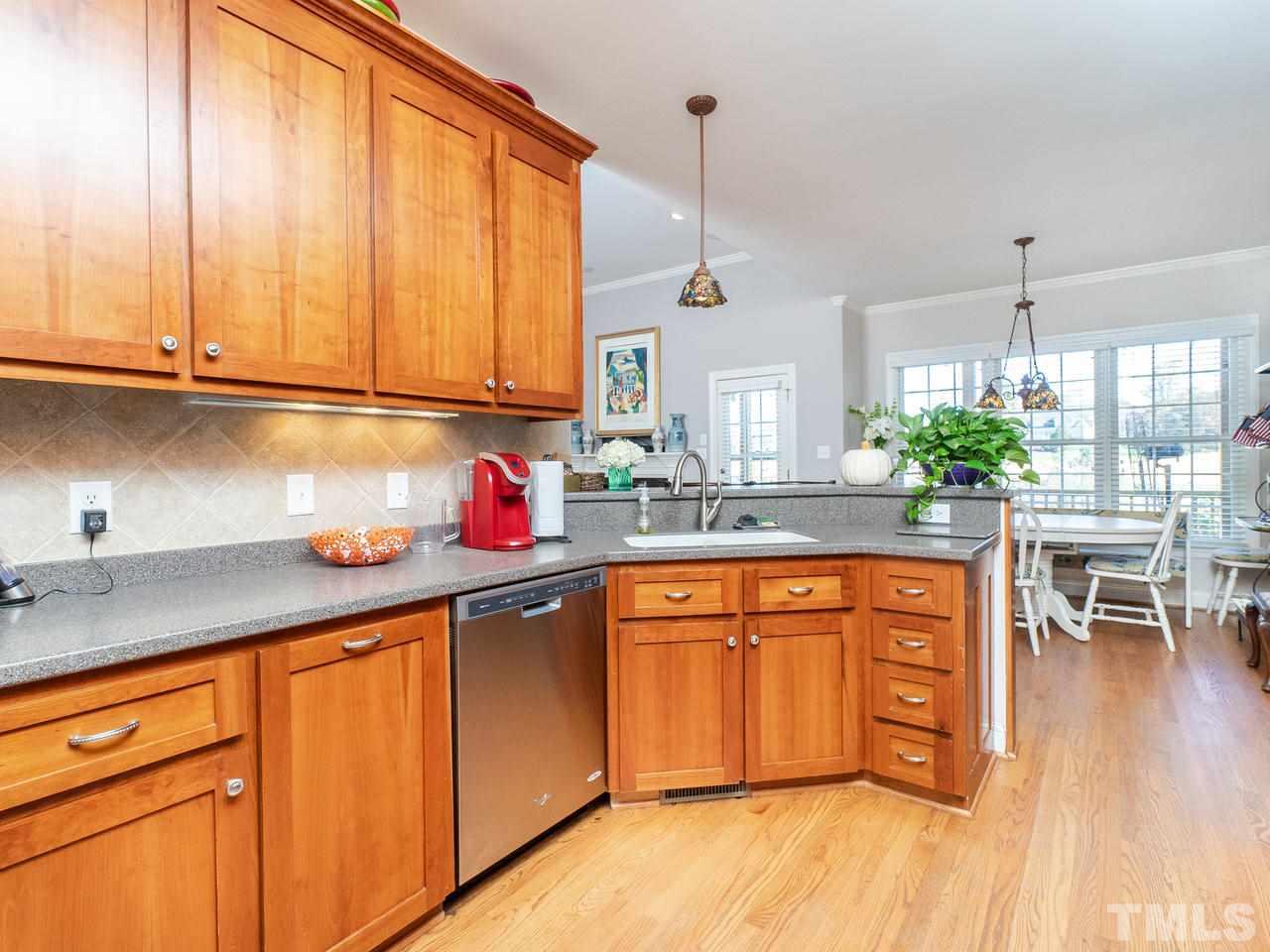 326 Challenge Road Raleigh, NC 27603 - Photo 12 of 30 a kitchen with stainless steel appliances granite countertop wooden cabinets a sink and dishwasher with wooden floor