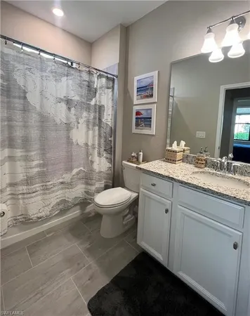 a bathroom with a double vanity sink toilet and shower