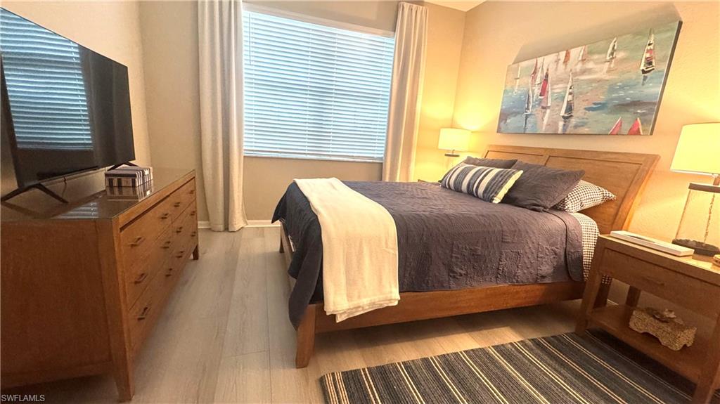 19824 Beechcrest Place Estero, FL 33928 - Photo 13 of 26 a bedroom with a bed and wooden floor
