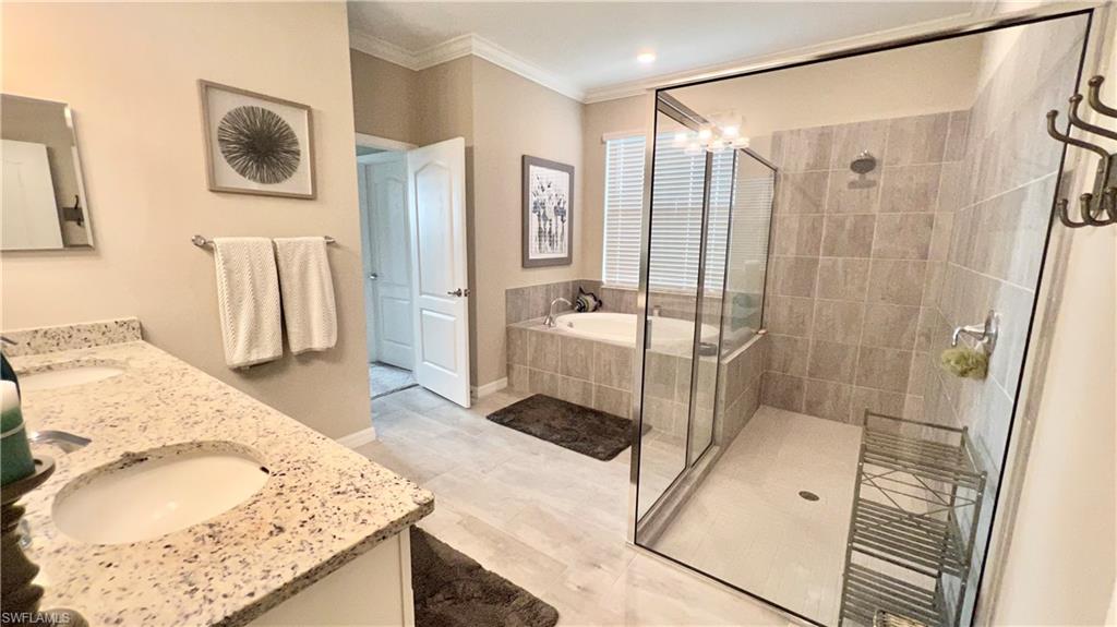19824 Beechcrest Place Estero, FL 33928 - Photo 15 of 26 a en suite spacious bathroom with a granite countertop double vanity sink a mirror and a shower