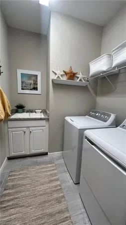 a utility room with a sink a stove and wooden floor