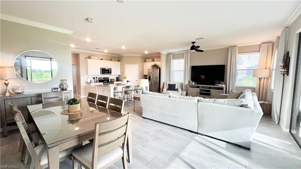 19824 Beechcrest Place Estero, FL 33928 - Photo 2 of 26 a living room with furniture a flat screen tv and a fireplace