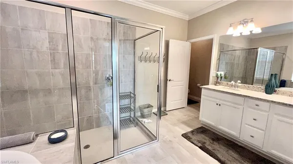 a bathroom with a double vanity sink mirror and shower