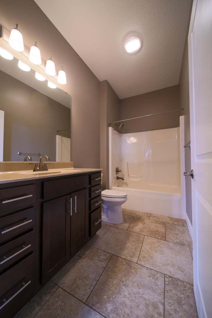 4935 Utica Ridge Road, Unit 220 Davenport, IA 52807 - Photo 20 of 29 a bathroom with a sink a toilet and a shower