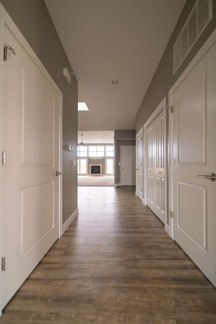 4935 Utica Ridge Road, Unit 220 Davenport, IA 52807 - Photo 21 of 29 a view of a hallway with wooden floor and a living room