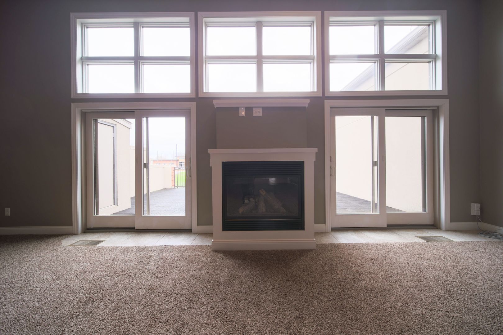4935 Utica Ridge Road, Unit 220 Davenport, IA 52807 - Photo 5 of 29 an empty room with large windows and fireplace