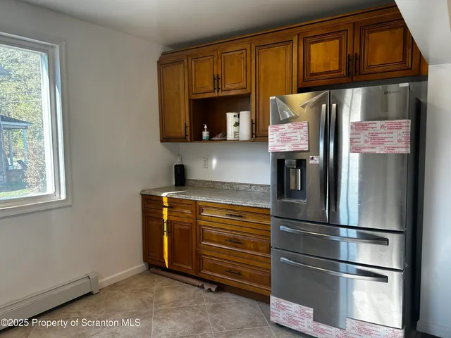 a kitchen with stainless steel appliances granite countertop a refrigerator and cabinets