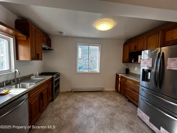 a kitchen with granite countertop a sink stainless steel appliances and cabinets