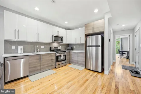 a kitchen with granite countertop a refrigerator and a stove top oven