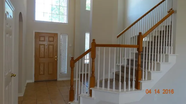 a view of staircase with railing and a window